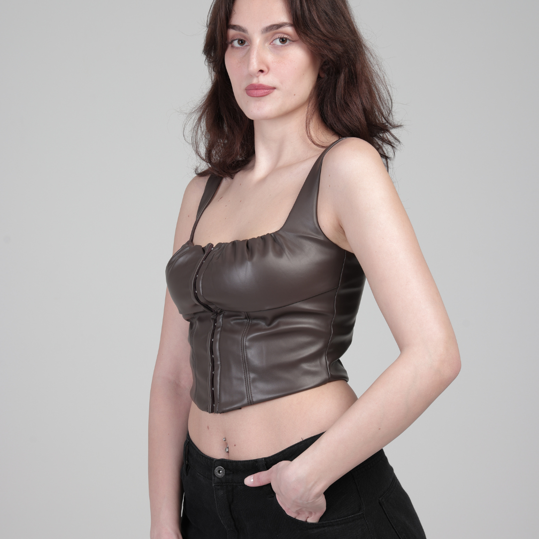 მოდელი ხელოვნური ტყავის კორსეტში, გვერდხედი, ხელი ჯიბეში