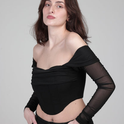 woman in black corset top with sleeves shows side of product, in front of white background. photo is over brest 