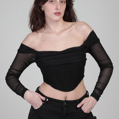 model in black corset top with sleeves, fort face photo. hands in pocket.